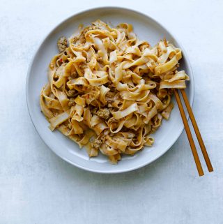 rice noodles on a plate with peanut and pork sauce