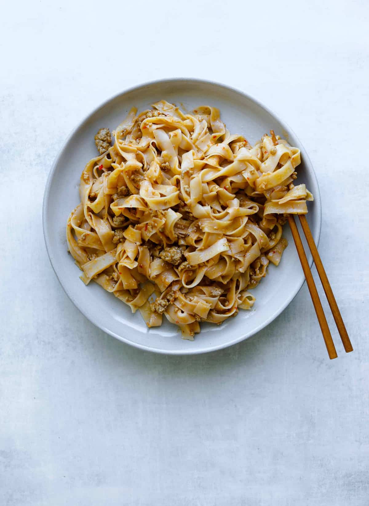 rice noodles on a plate with peanut and pork sauce