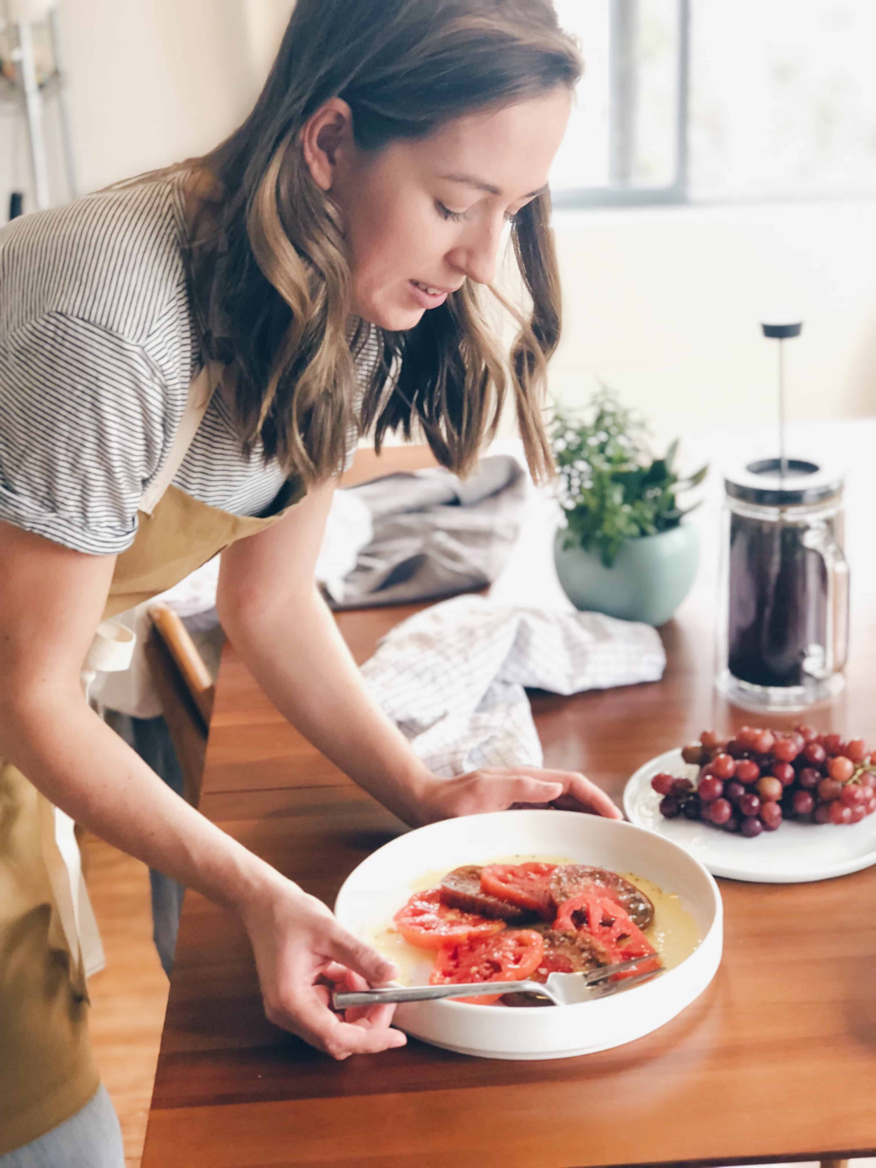 Leigh Hyatt Anderson serving a platter of tomato salad