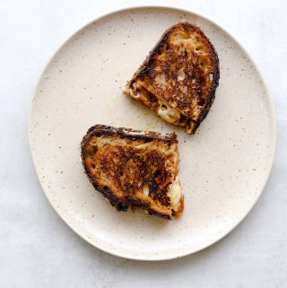 Golden brown White Cheddar + Fig Grilled Cheesegrilled cheese on a white plate