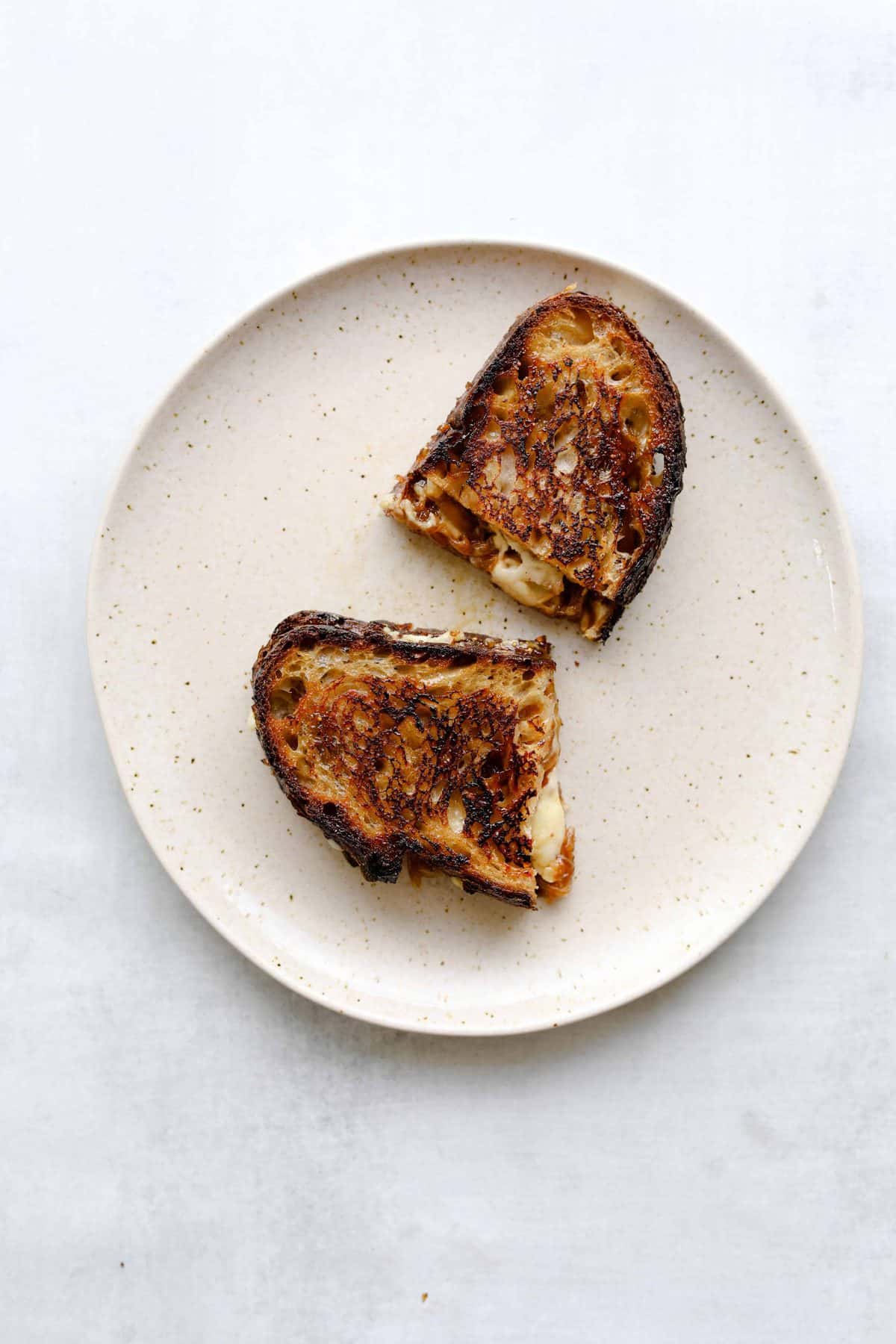 Golden brown White Cheddar + Fig Grilled Cheesegrilled cheese on a white plate