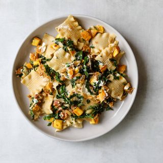 The Perfect Fall Pasta with Pancetta, Squash, Goat Cheese + Kale on a white plate