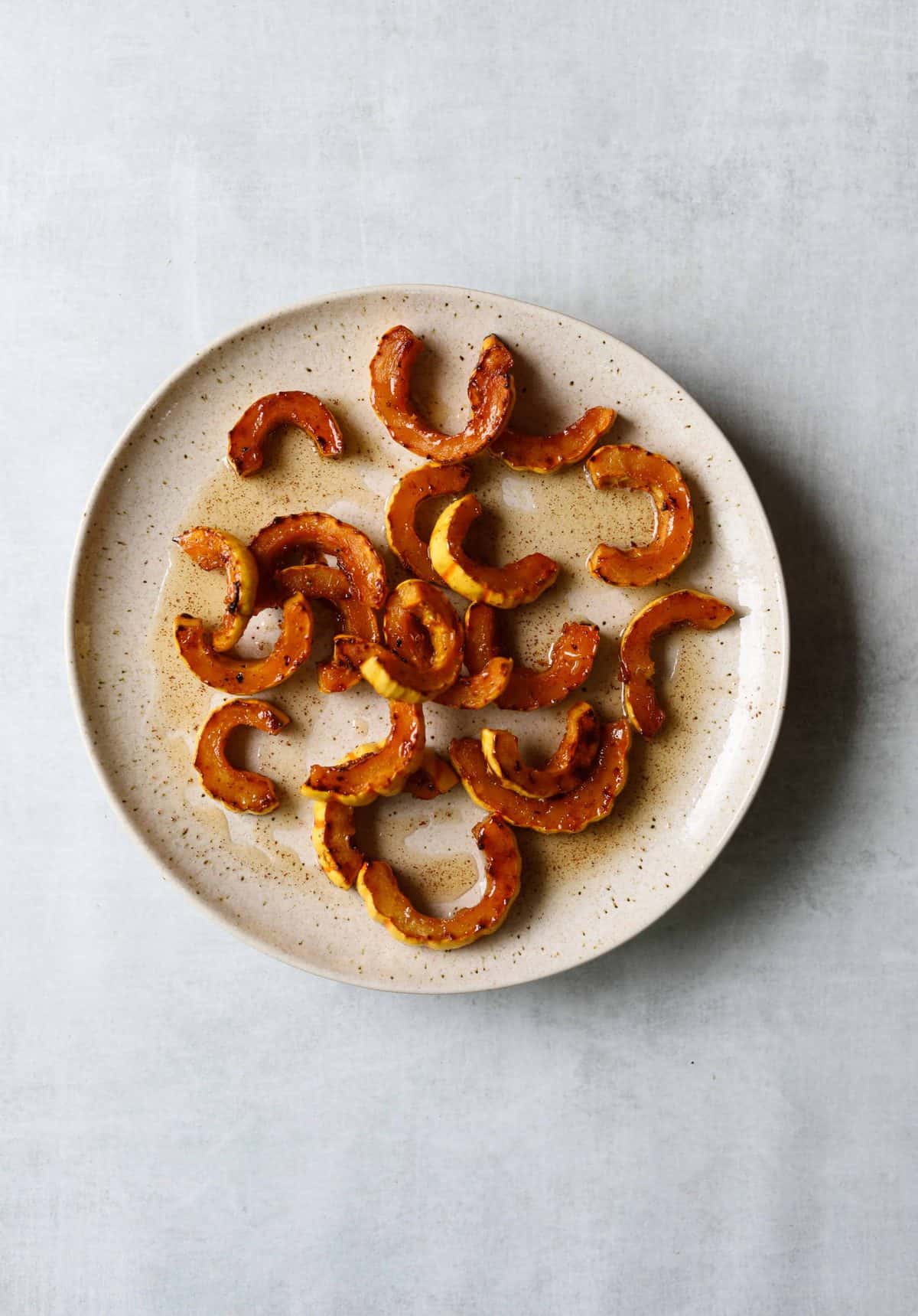 Maple- brown butter roasted squash on a white plate