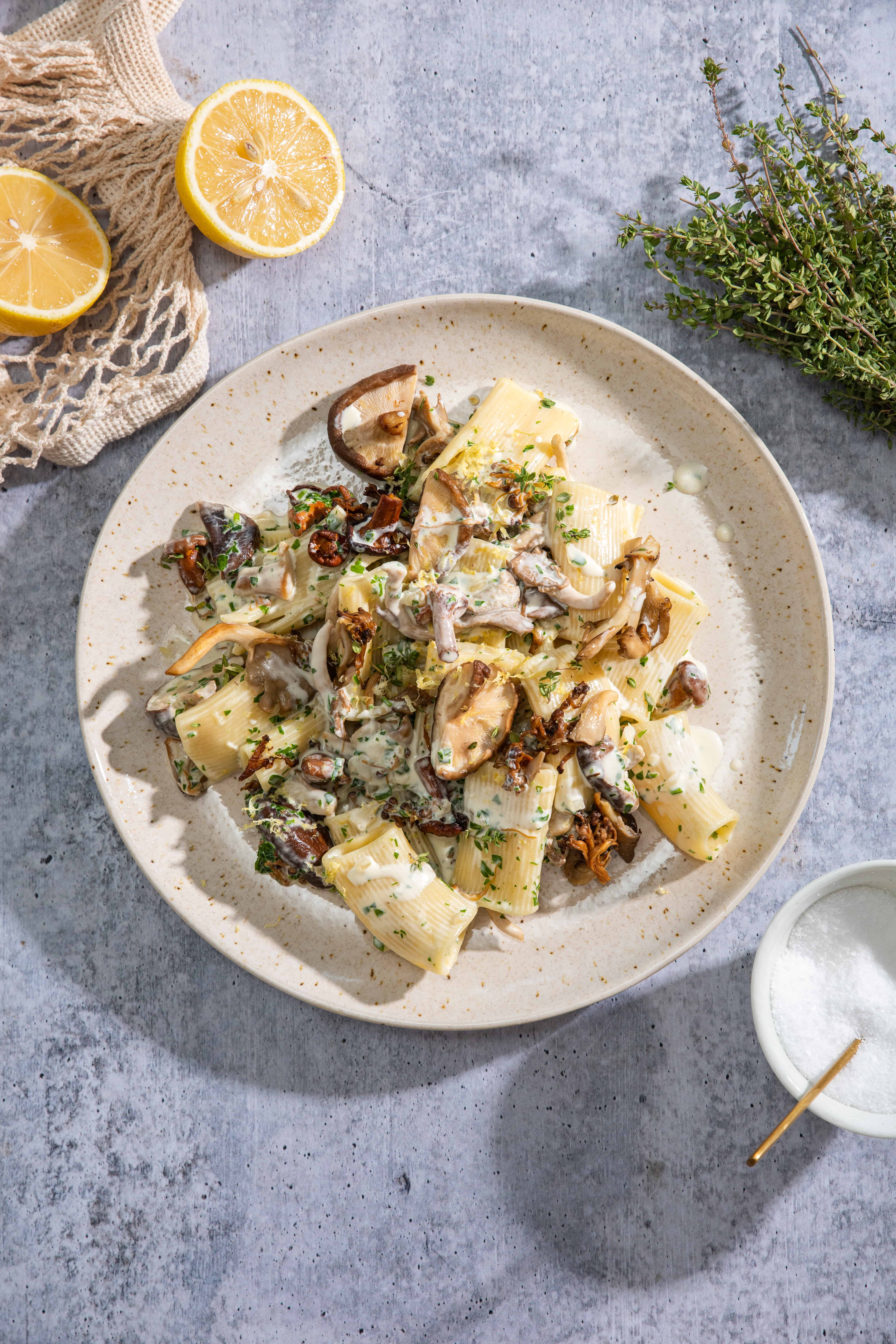 Creamy Mushroom and Garlic Pasta on a ceramic plate with lemon zest, fresh thyme and parsley