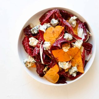 Persimmon and Blue Cheese Salad with Grainy Mustard Vinaigrette in a bowl