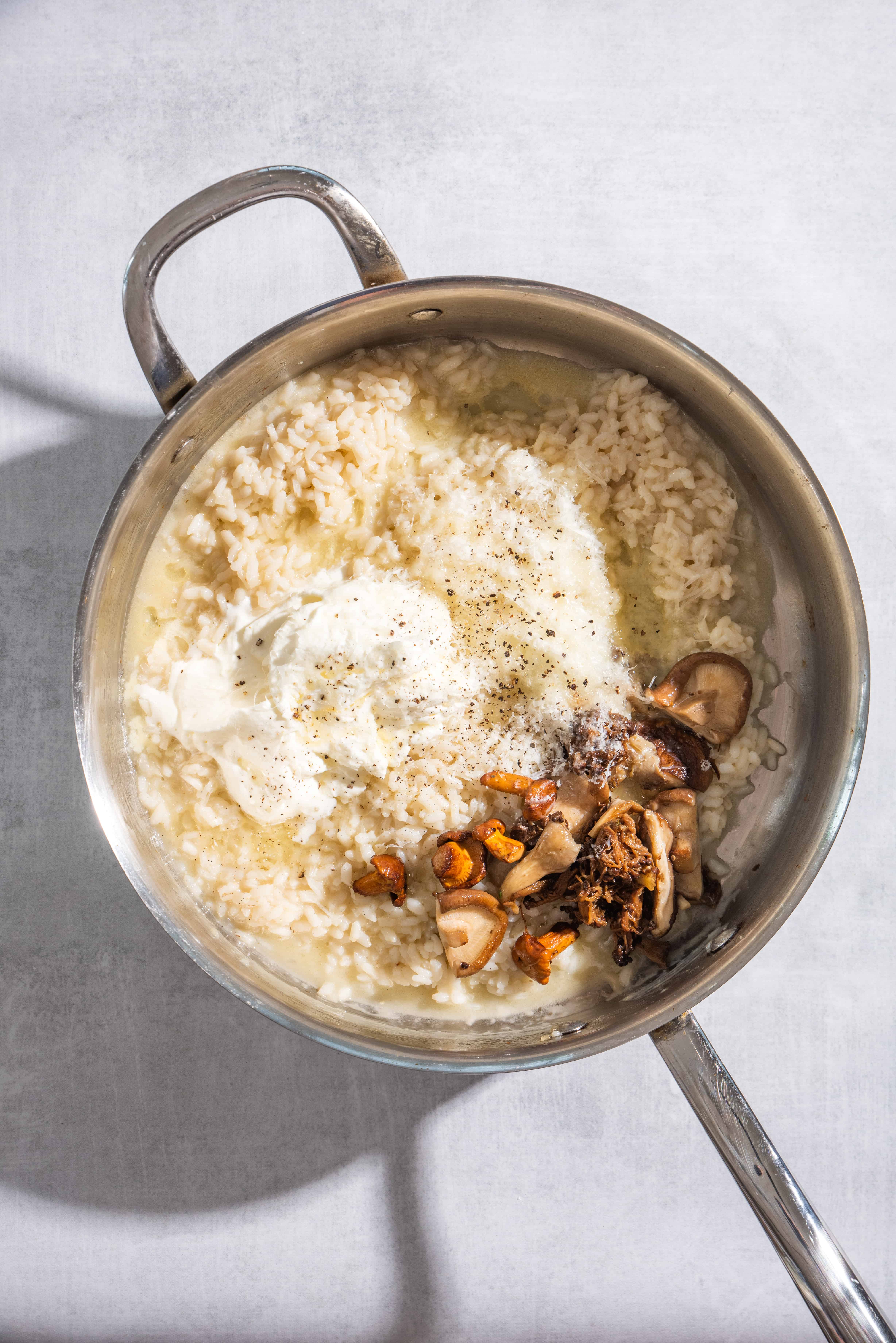 Creamy Roasted Mushroom Risotto with Truffle Oil in a pot being stirred together