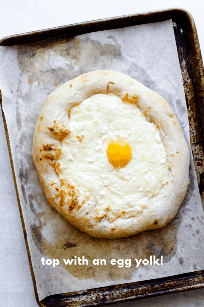 Khachapuri Pizza on a baking tray with an egg yolk