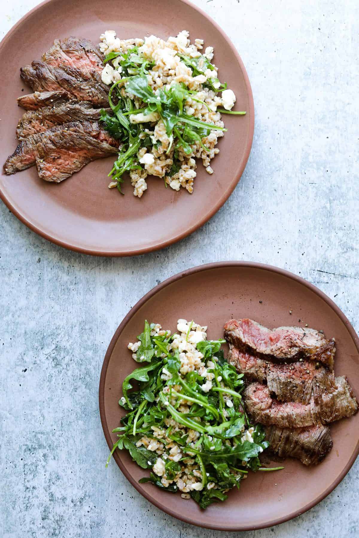 Two Plates of Five-Ingredient Steak Salad with Farro, Arugula, and Feta