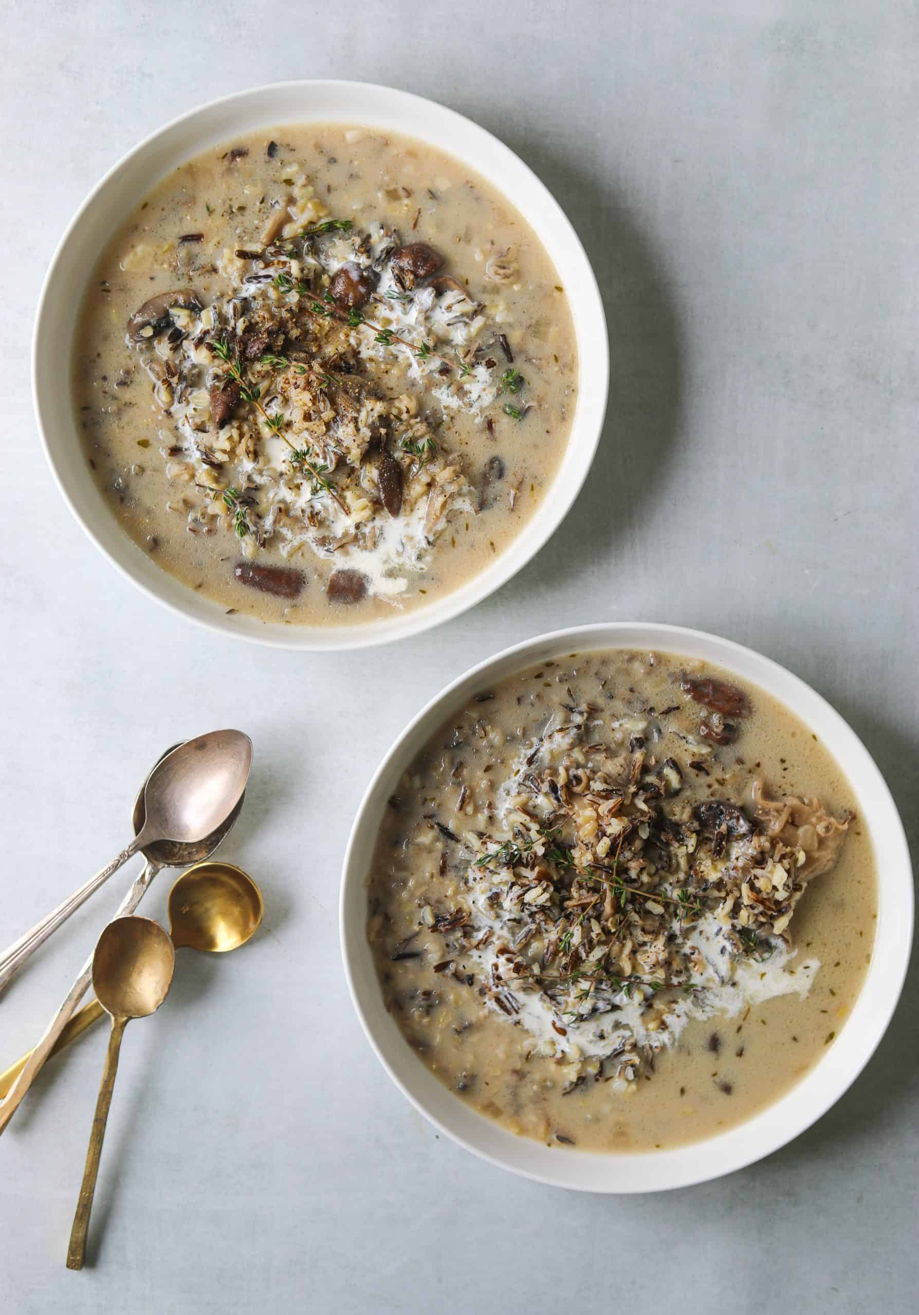 two bowls of Wild Rice and Mushroom Soup with a drizzle of coconut milk and fresh thyme