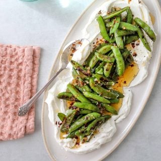 a platter with Roasted Snap Peas with Yogurt and Garlic Chili Oil