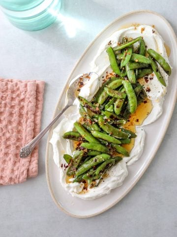 a platter with Roasted Snap Peas with Yogurt and Garlic Chili Oil