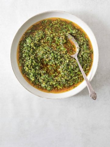 Chimichurri in a bowl with a silver spoon