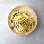a white bowl filled with Bucatini al Limone with Wilted Kale