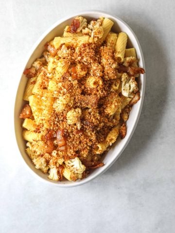 a white oval serving dish filled with Roasted Cauliflower Carbonara with Garlic Breadcrumbs