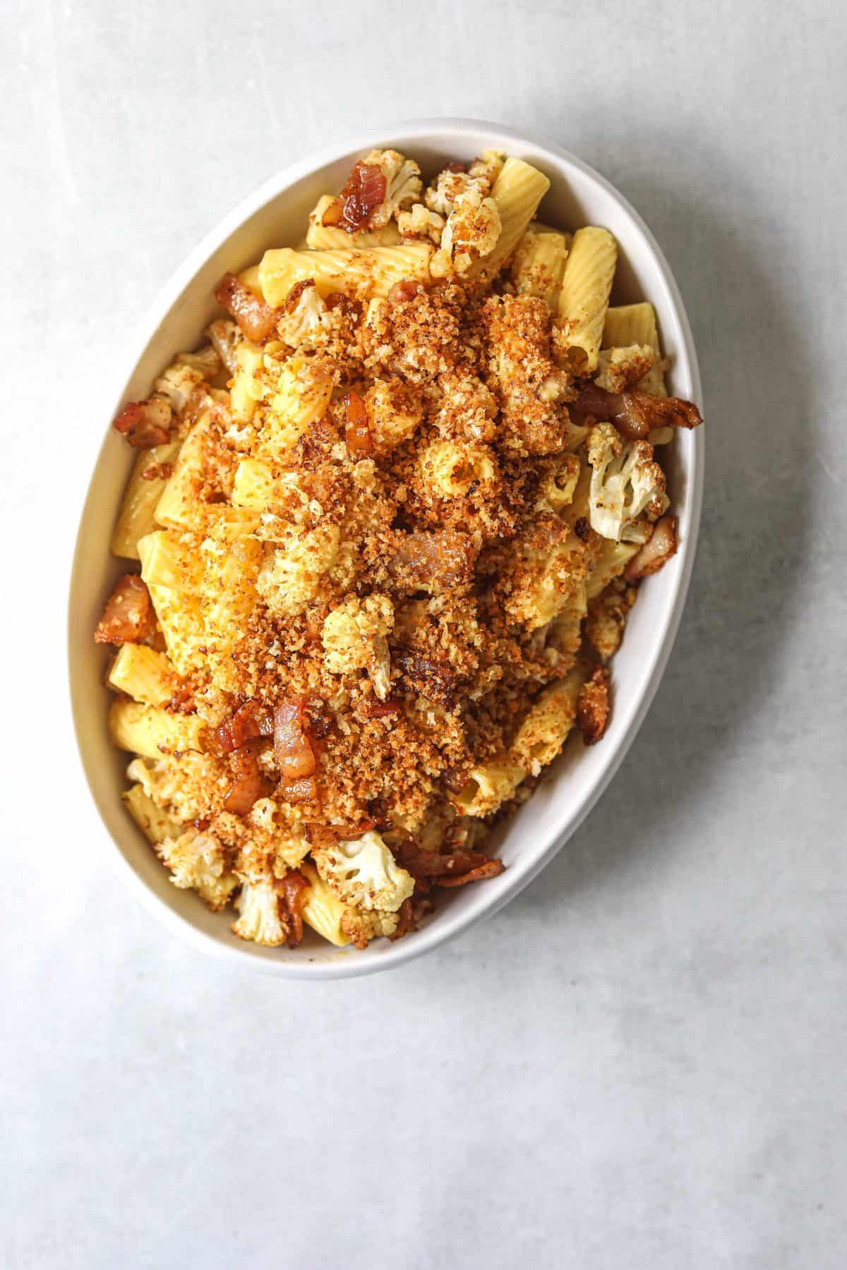 a white oval serving dish filled with Roasted Cauliflower Carbonara with Garlic Breadcrumbs
