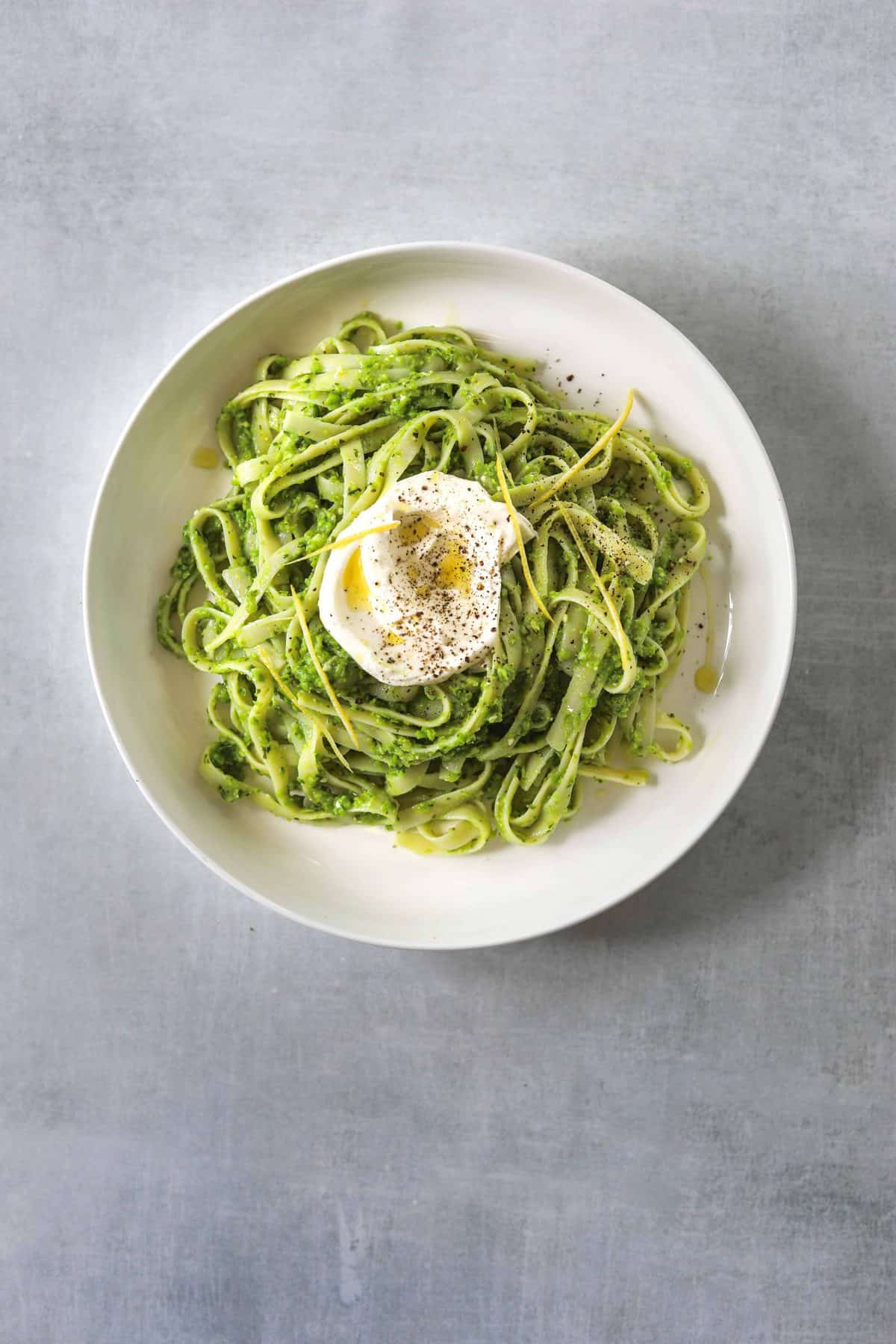 a white bowl filled with Tagliatelle with Pea Pesto and Creme Fraiche