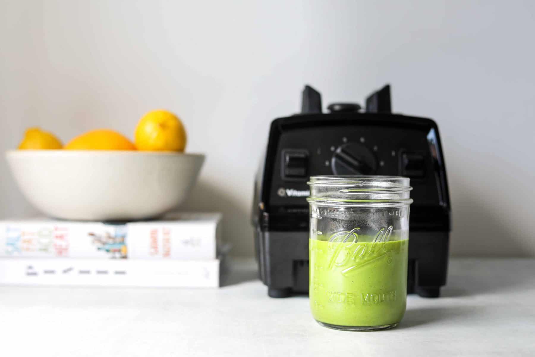 A mason jar filled with Lemon + Basil Vinaigrette