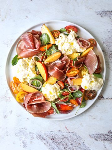 a white plate filled with Burrata Salad with Prosciutto and Nectarines