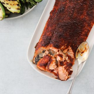 An oval platter with Oven Roasted BBQ Salmon and a side of grilled veggies