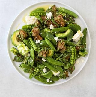 a white plate filled with Avocado Panzanella with Snap Peas + Feta Cheese