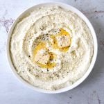 a white bowl filled with Cacio e Pepe Mashed Cauliflower