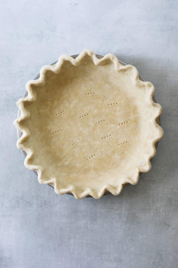 a raw pie crust in a pie tin