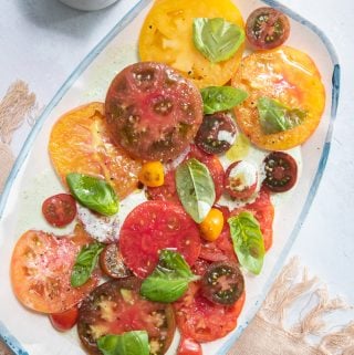a platter filled with heirloom tomato salad with buttermilk-basil dressing
