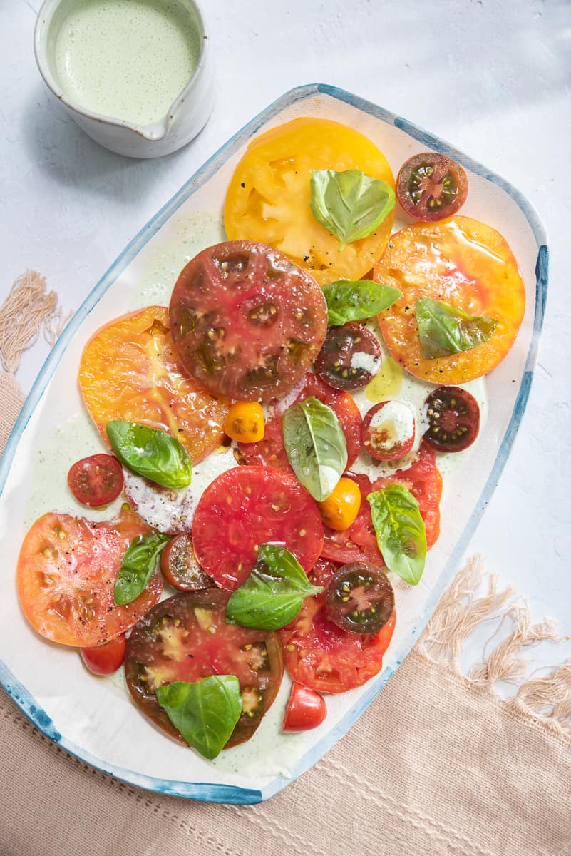 a platter filled with heirloom tomato salad with buttermilk-basil dressing 