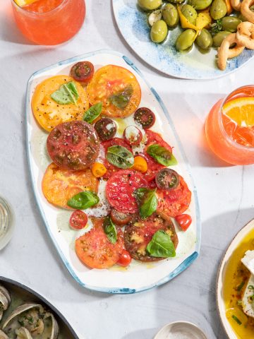 a platter filled with heirloom tomato salad with buttermilk-basil dressing