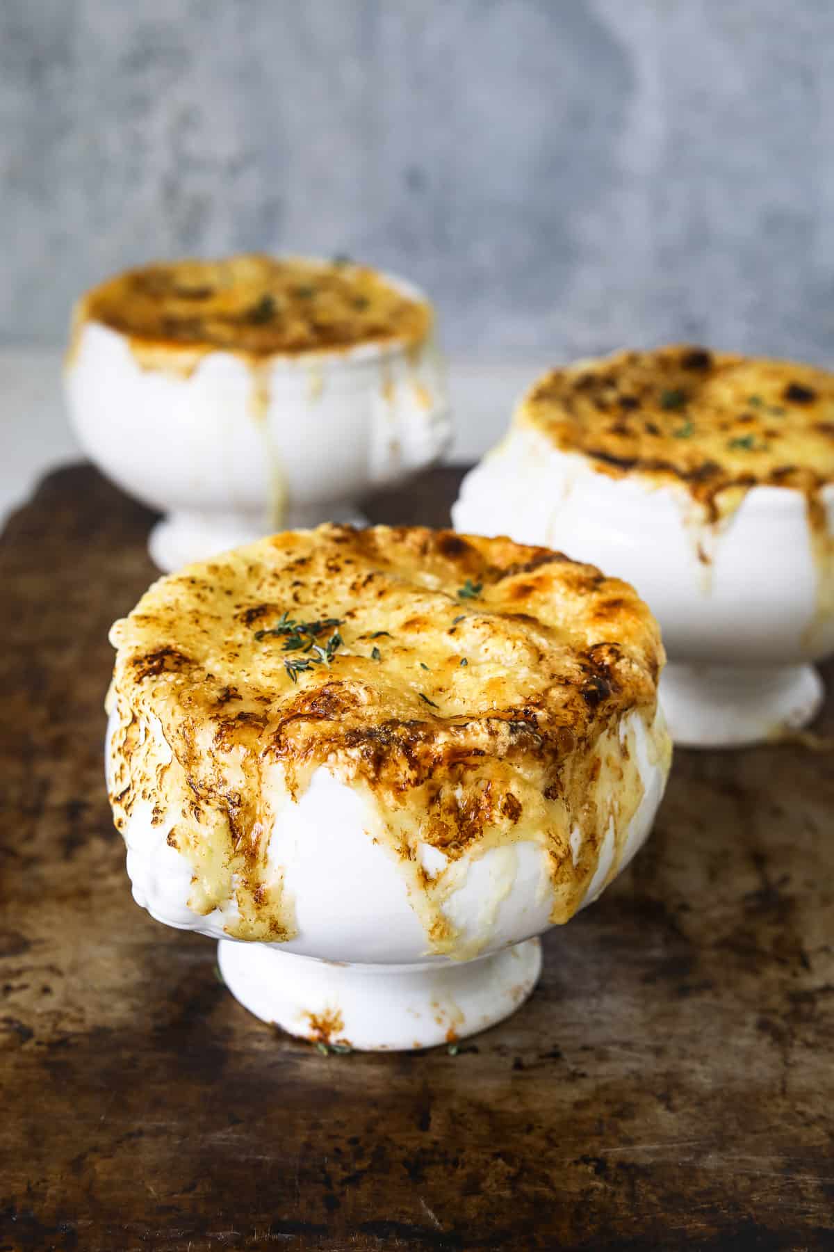 three crocks of vegetarian french onion soup topped with golden brown melted cheese