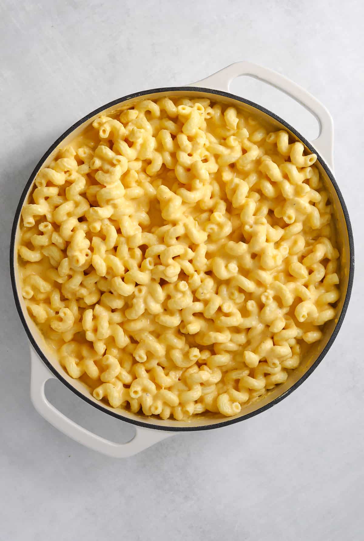 a large pot of butternut squash macaroni and cheese on a blue background
