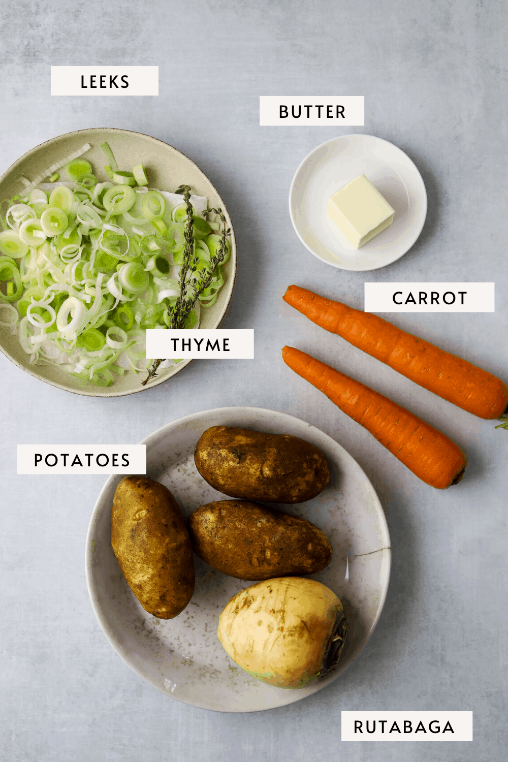 recipe ingredients, two carrots, chopped leeks in a bowl, fresh thyme, potatoes, rutabaga 