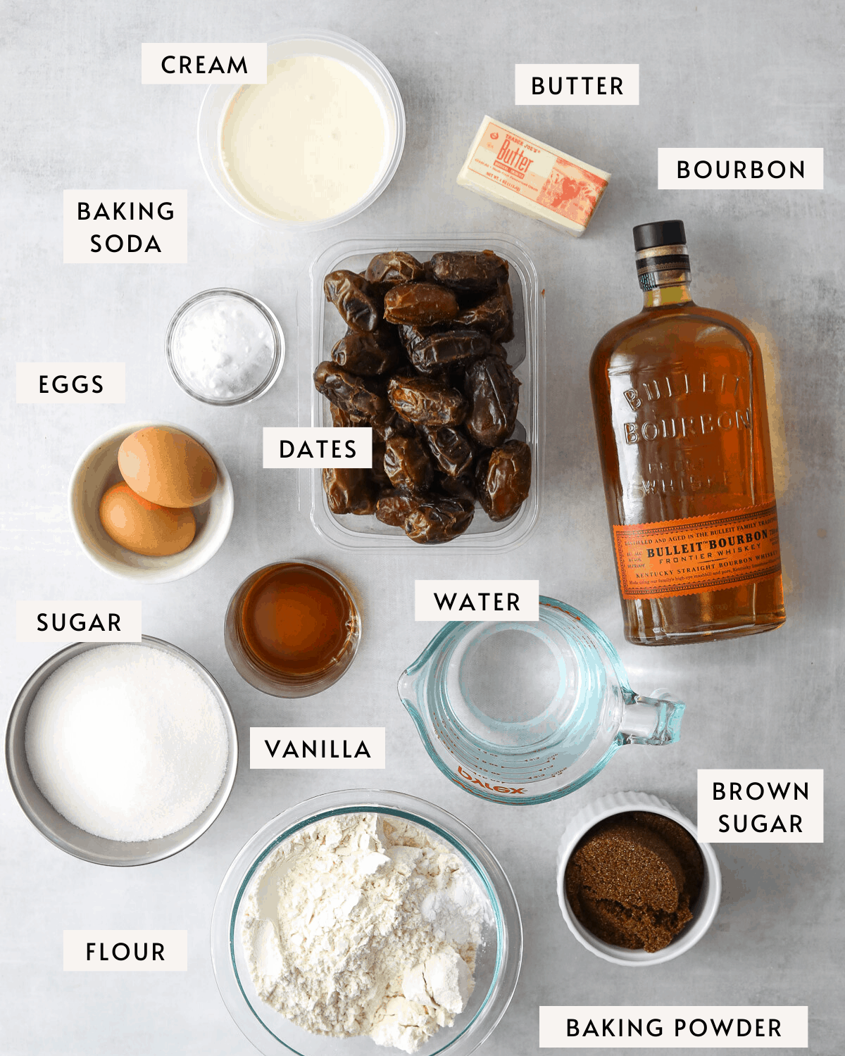 date cake ingredients portioned out into individual dishes. fresh dates, a bottle of bourbon, a stick of butter etc. 