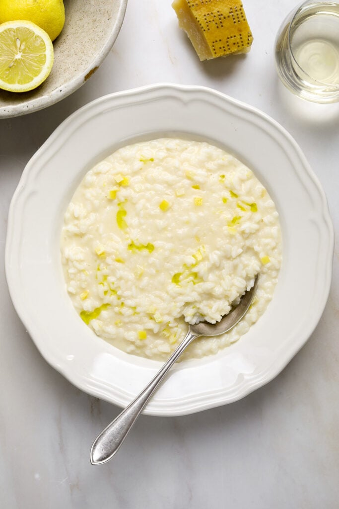 A bowl of risotto with a silver spoon.