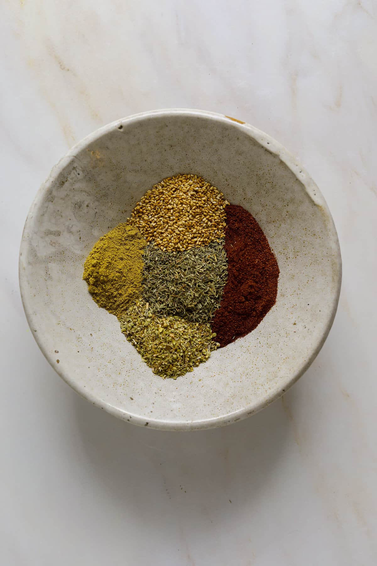 A bowl with individual sections of different spices.