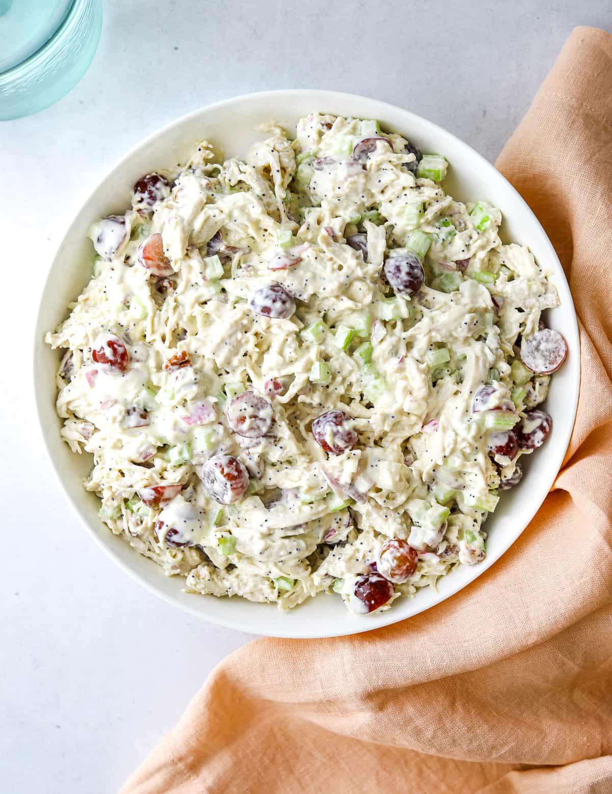 a white bowl filled with creamy Sonoma Chicken Salad and pink tea towel.