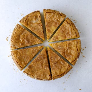 a gluten-free citrus and olive oil cake cut into six slices on a blue background
