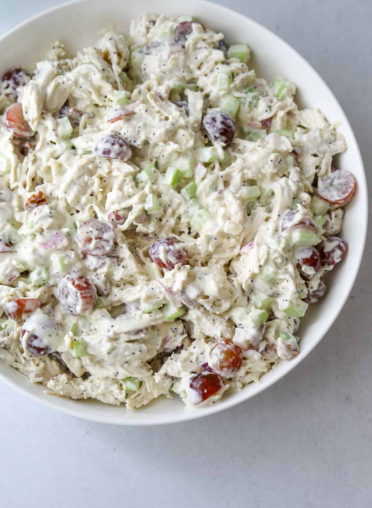 a white bowl filled with Sonoma Chicken Salad with grapes, celery and creamy dressing