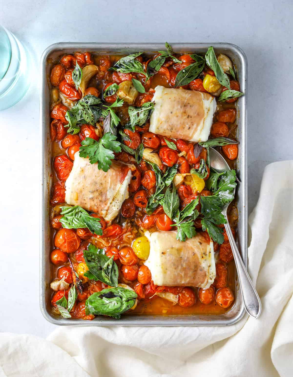 a sheet pan with Prosciutto Wrapped Halibut with Slow-Roasted Tomatoes