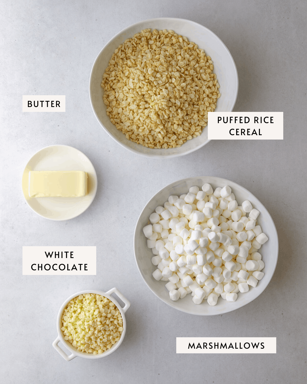 recipe ingredients: a bowl of mini marshmallows, white chocolate chips, puffed rice cereal, and butter