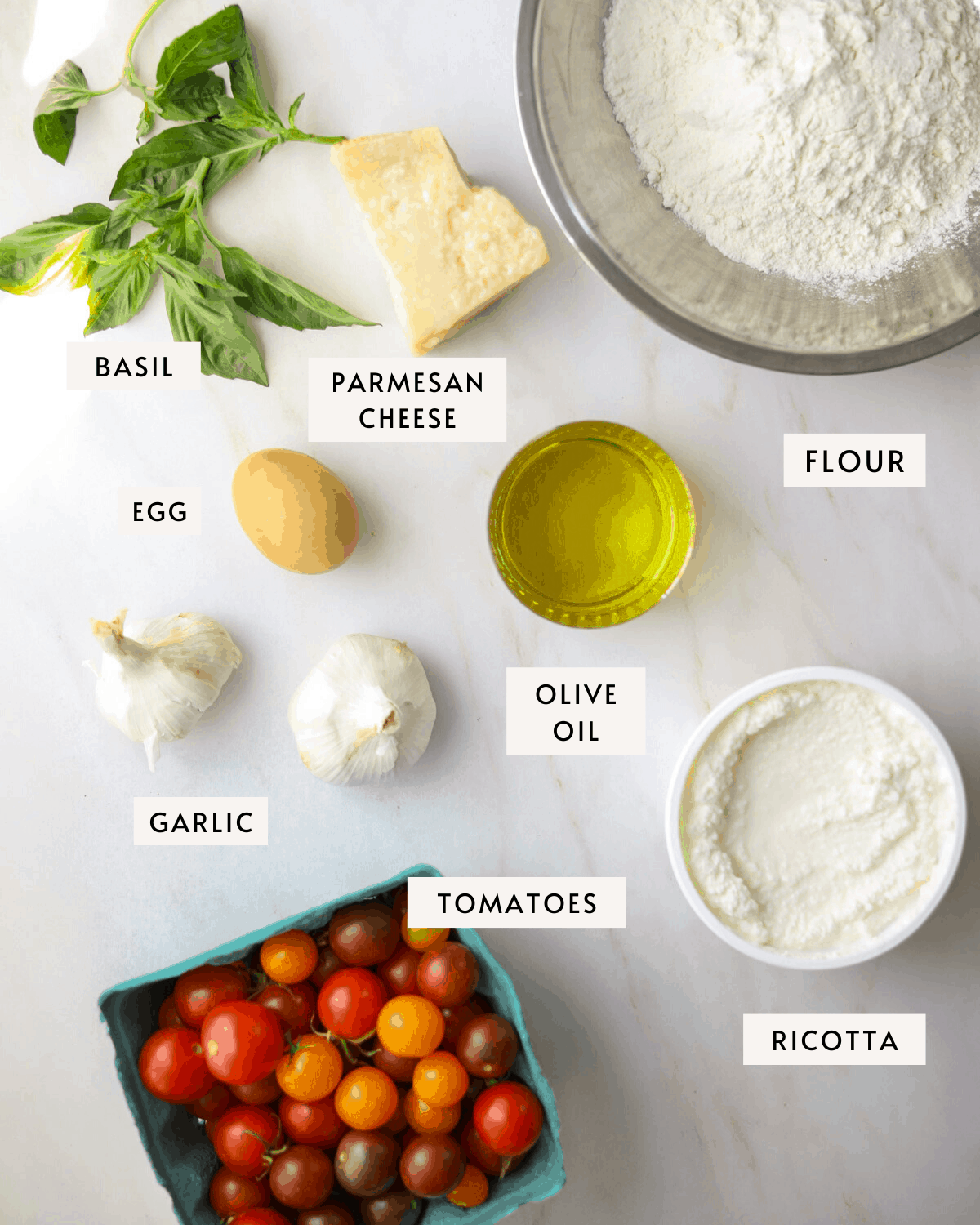 recipe ingredients individually portioned: flour, olive oil, tomatoes, ricotta, garlic and basil