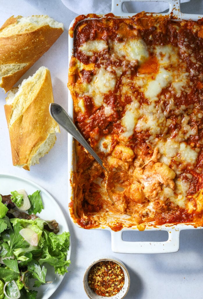 a white backing dish with baked gnocchi and mozzarella cheese