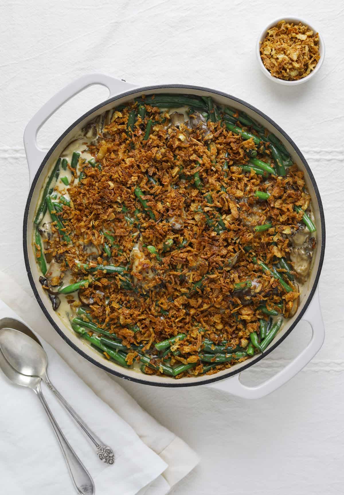 a white pan with green bean casserole on a white background