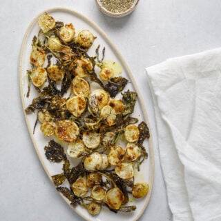 an oval platter with roasted baby turnips with a small dish of za'atar spice and a white linen napkin