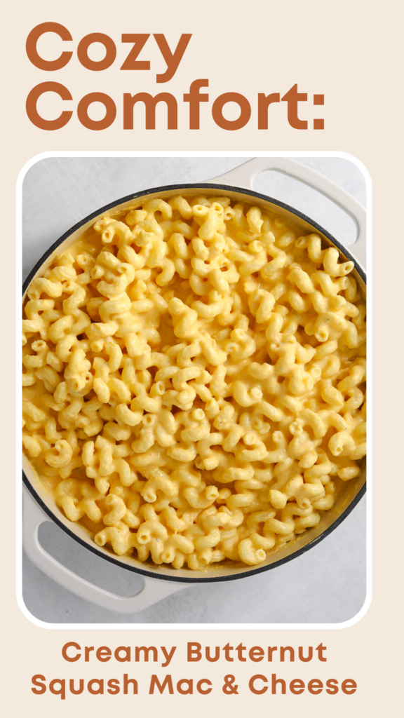 A round white enamel baking dish filled with bright yellow macaroni and cheese.