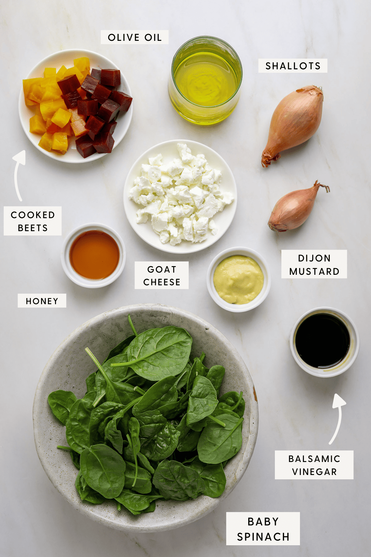 Recipe ingredients portioned into individual bowls; balsamic vinegar, spinach, shallots, olive oil and cooked beets.