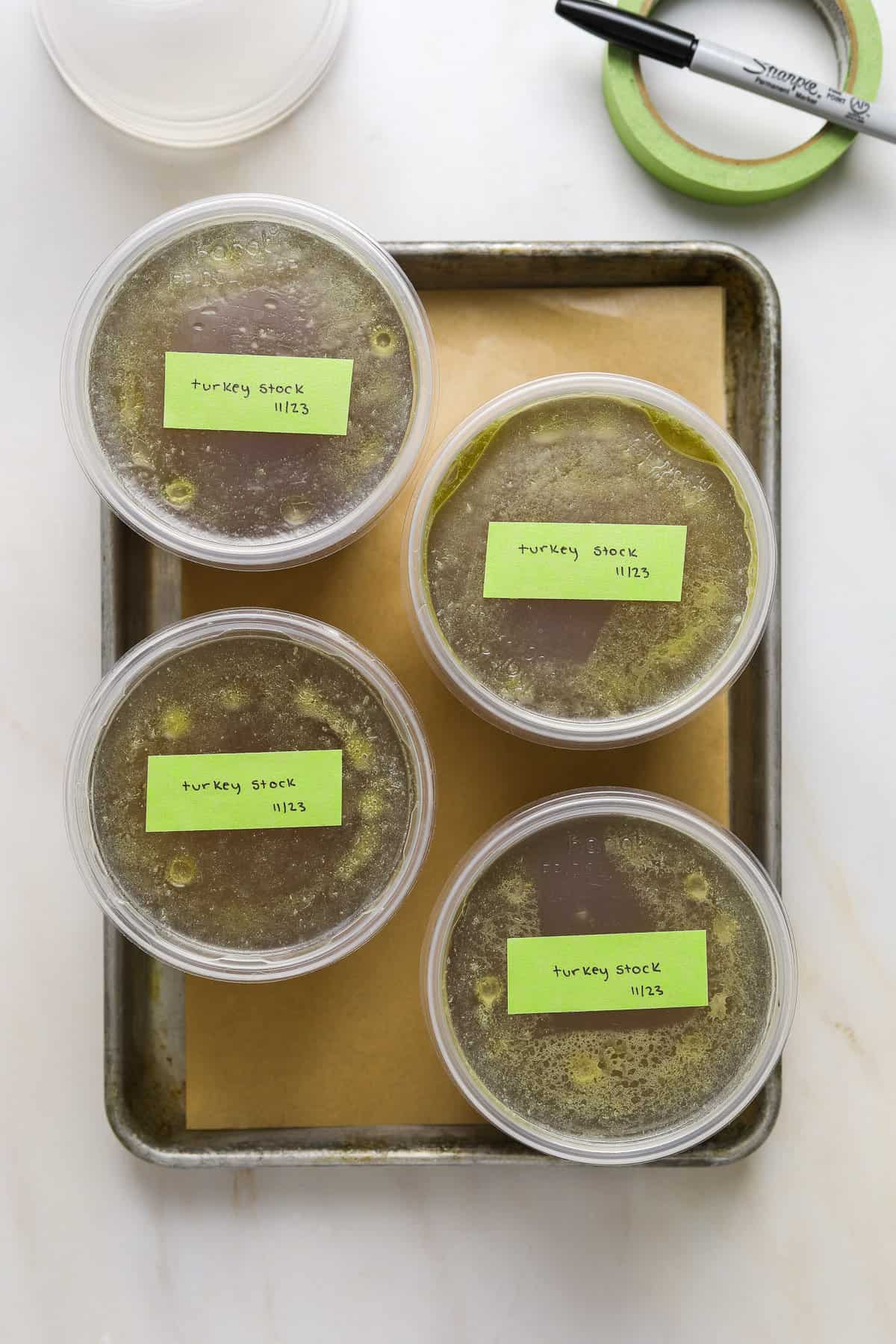 Plastic quart containers of turkey stock, labeled with green tape.