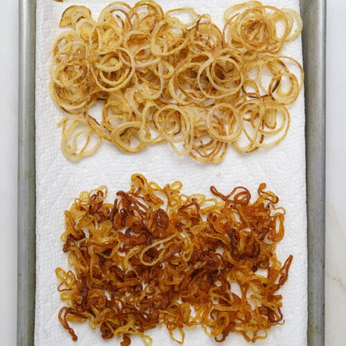 A baking tray with two different types of fried shallots.