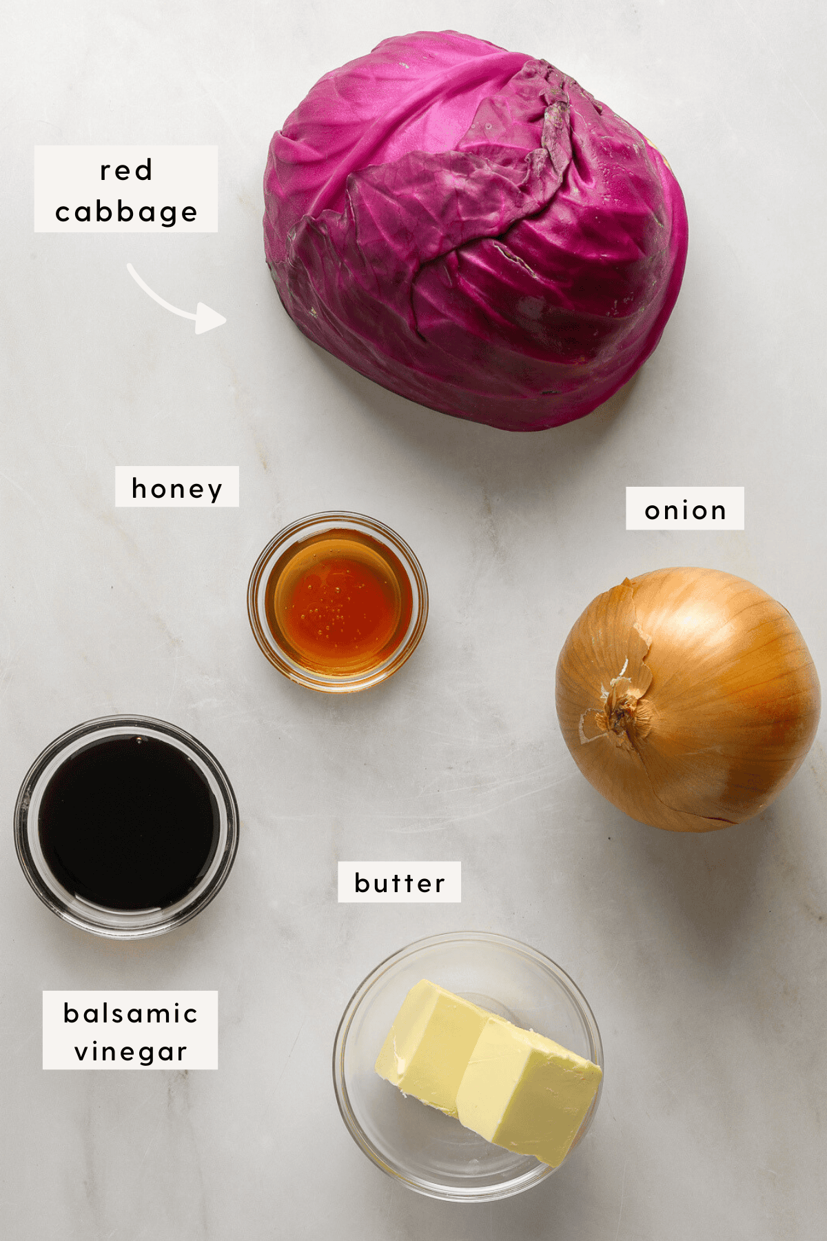 Half a red cabbage, small glass bowls filled with; butter, balsamic vinegar, and honey.