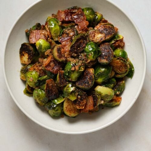 A bowl of cooked, halved brussels sprouts.